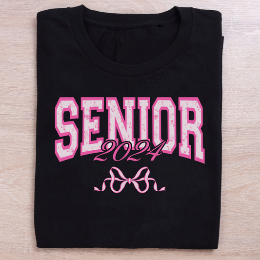 Black shirt with the word Senior 2024 across the middle with a pink bow.